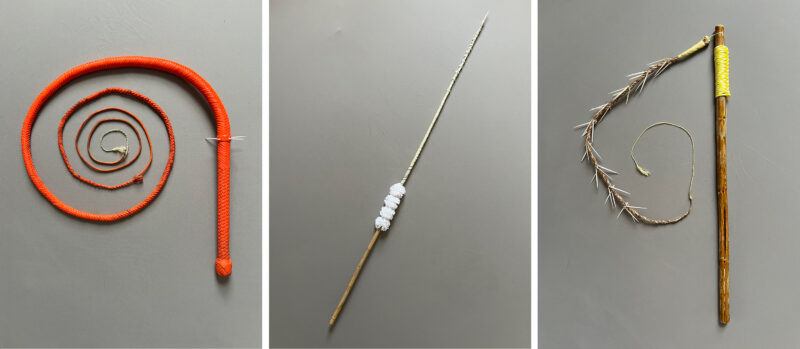 Three types of whips are displayed side by side: a coiled red whip, a long slender whip with white wrappings, and a wooden handle whip with a yellow grip and barbed segment.